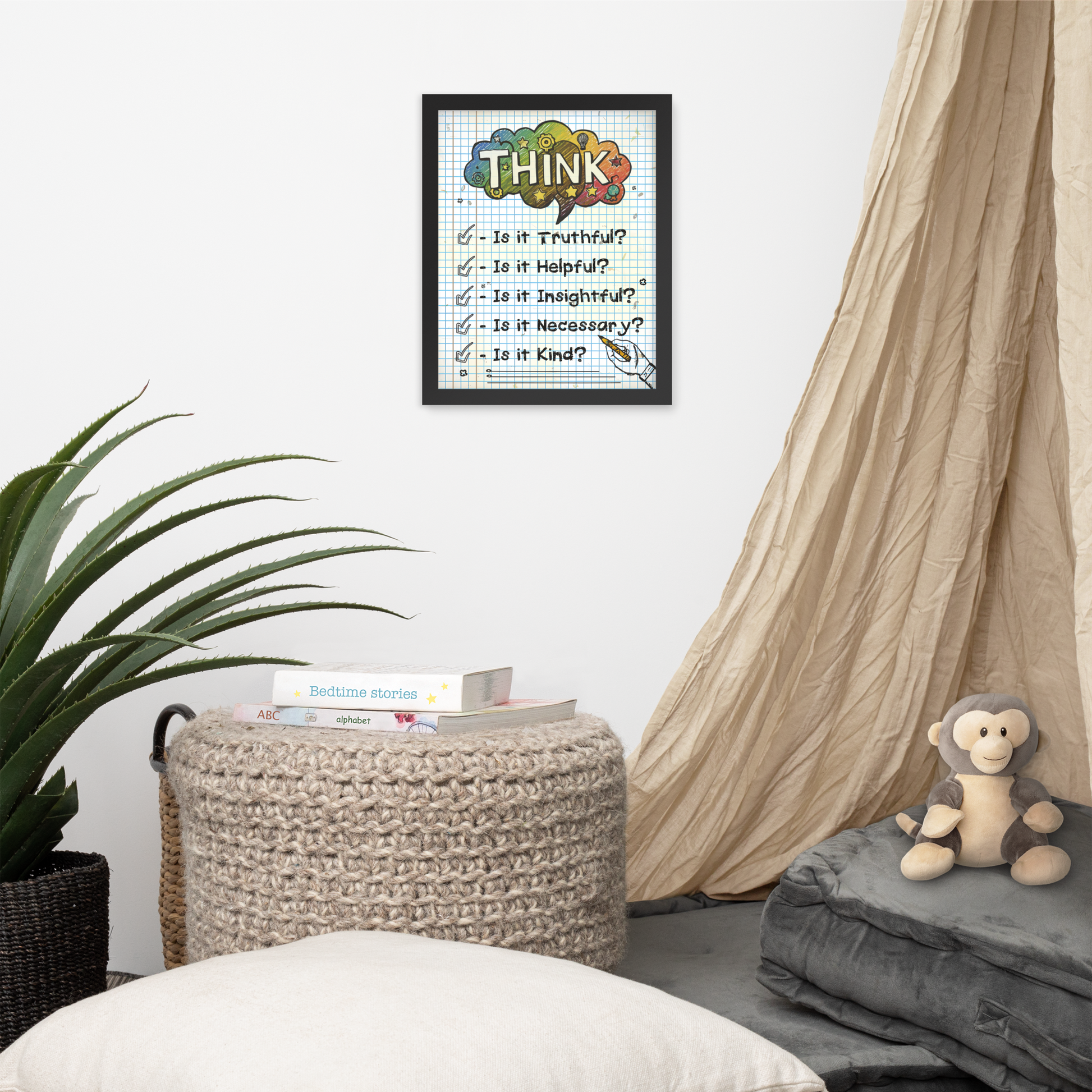 Framed illustrated poster with a black frame titled 'THINK' featuring a checklist with items: Is it Truthful?, Is it Helpful?, Is it Insightful?, Is it Necessary?, Is it Kind?. The poster hangs on a white wall above a cosy nook with a knitted pouffe, books, a plant, and a plush monkey toy.